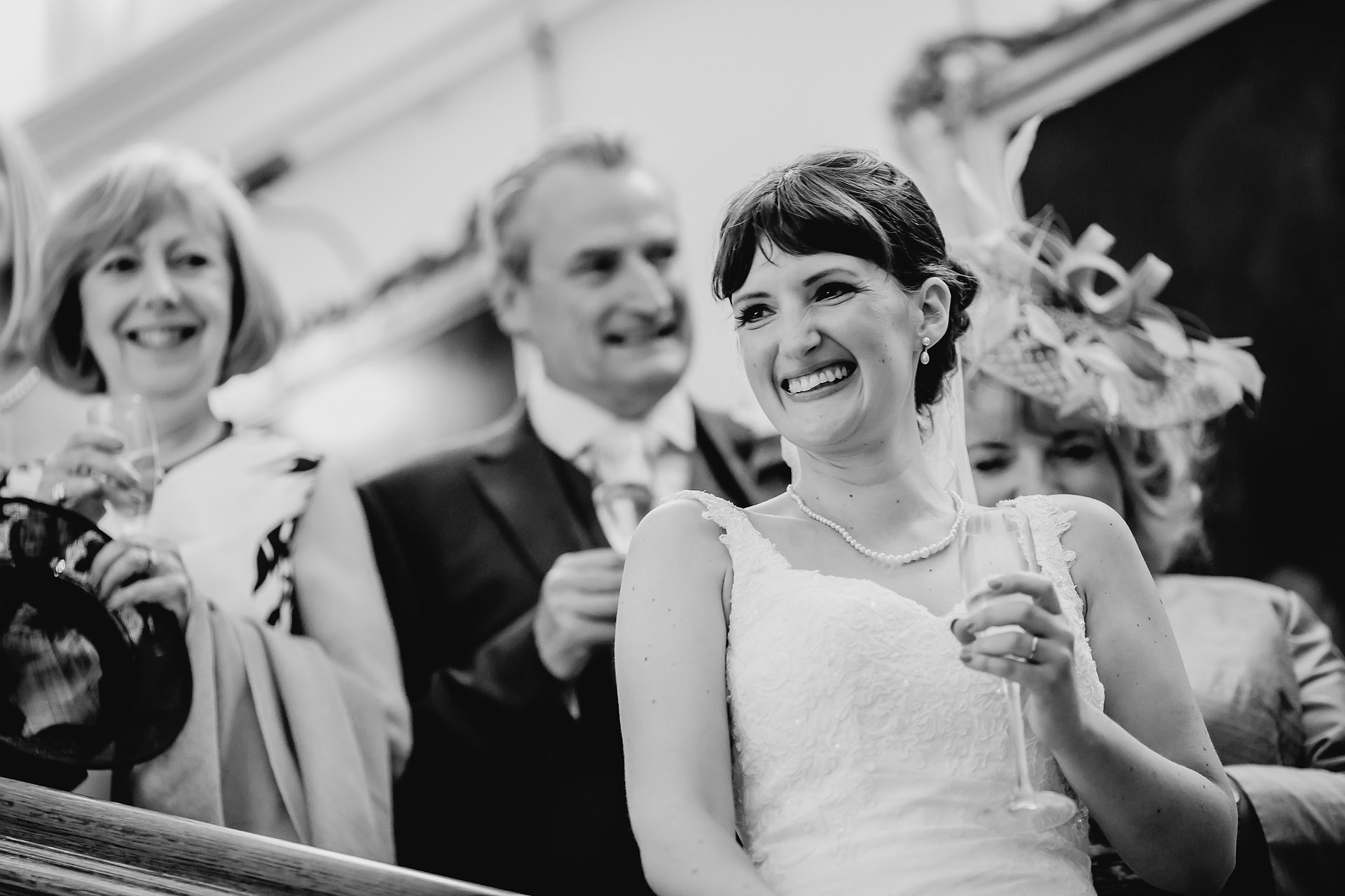 bride laughing during the speeches on the staircase - capesthorne-hall-wedding-photographer