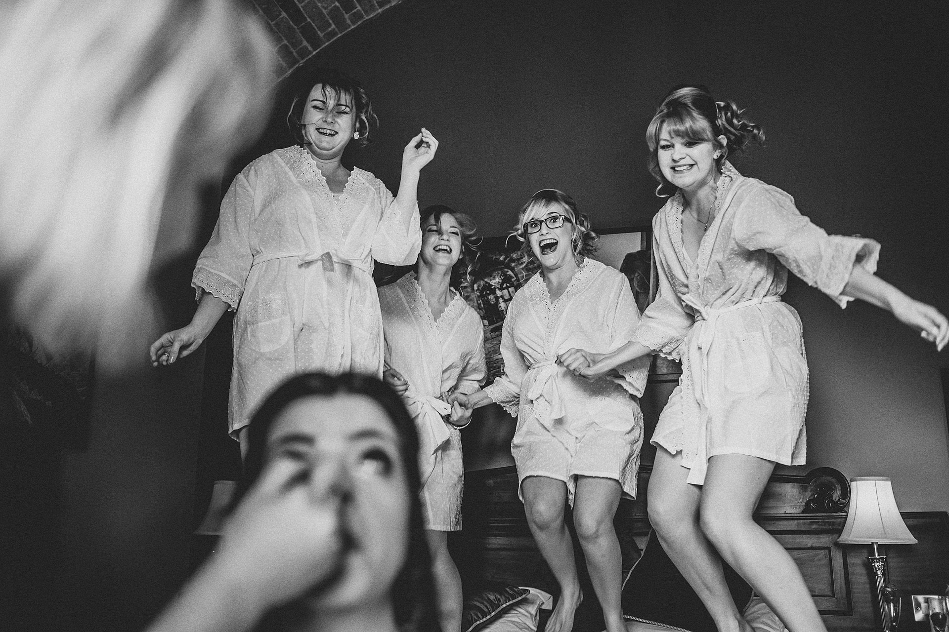 bridesmaids jumping on the bed