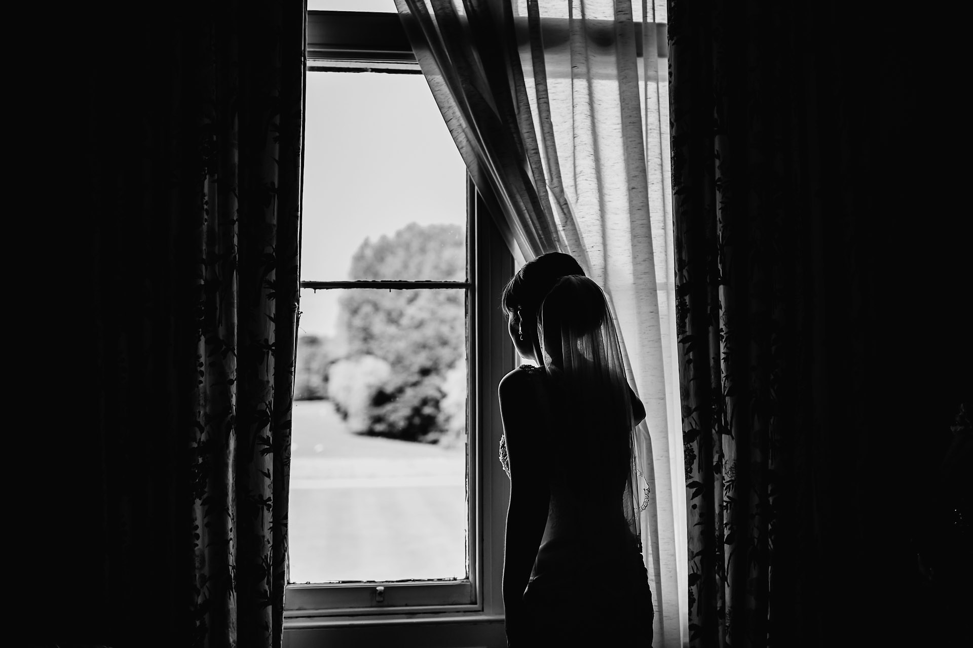 photo of the bride looking out of the window at capesthorne hall 