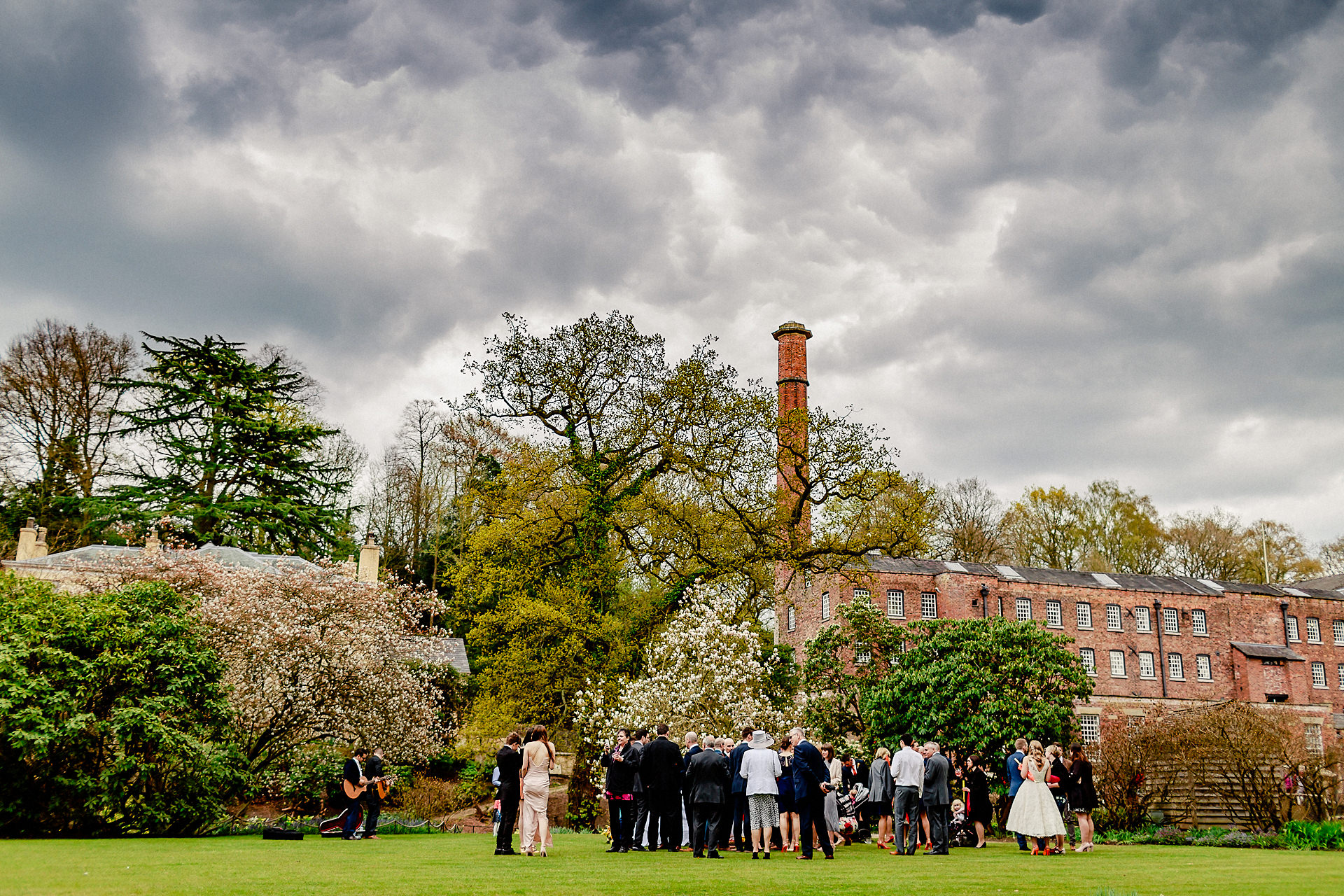 bridesmaids and wedding guests having a drink in the grounds of quarry bank mill 