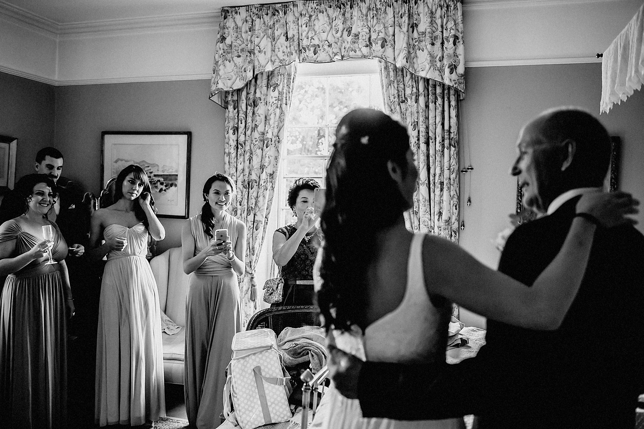 bride and dad with bridesmaids watching 