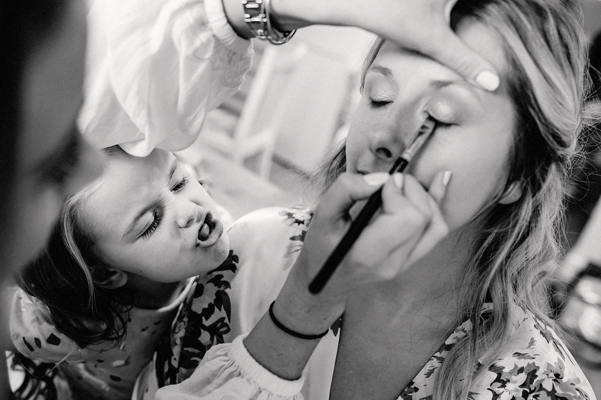 little girl pulling a face during make up before the wedding