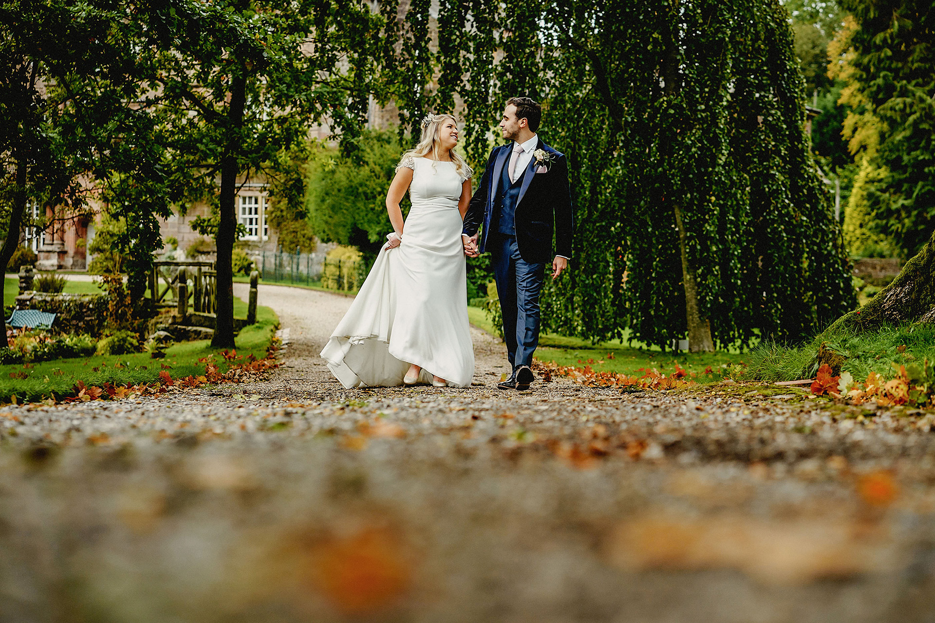 bride and groom walking down the path in the browsholme estate