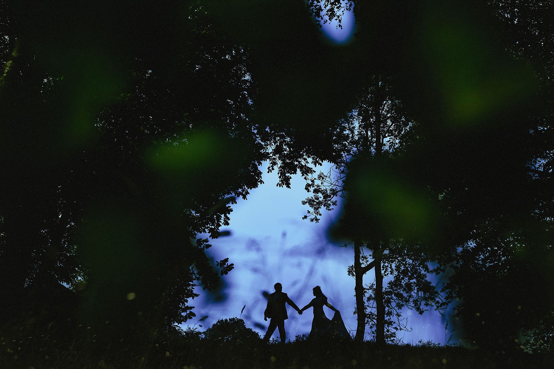 photo of the bride and groom silhouetted in the sky