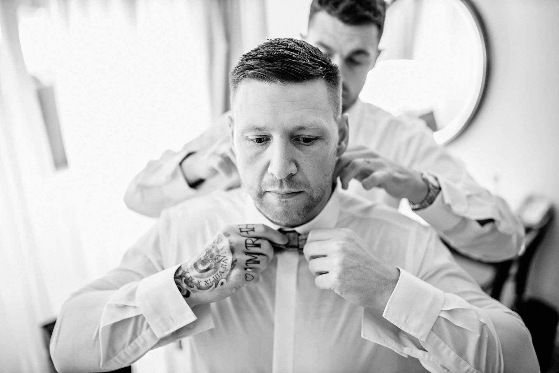 groom gettin ghis bow tie put on by the best man at bartle hall 