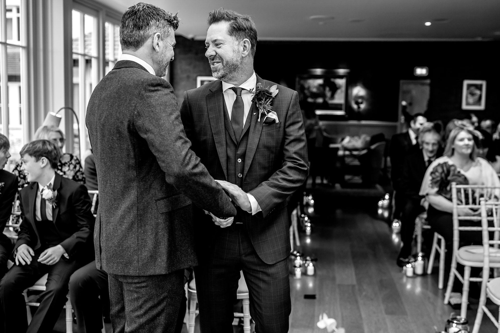 best man and groom shaking hands